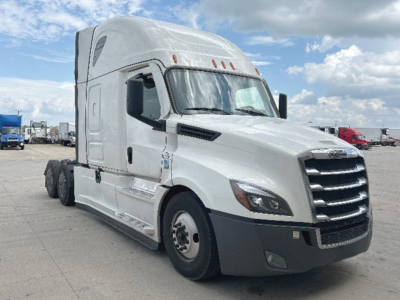 Freightliner Cascadia126 sleeper tractor in a parking lot, white exterior with black front bumper, three axles with dual rear wheels, VIN plate area not visible.