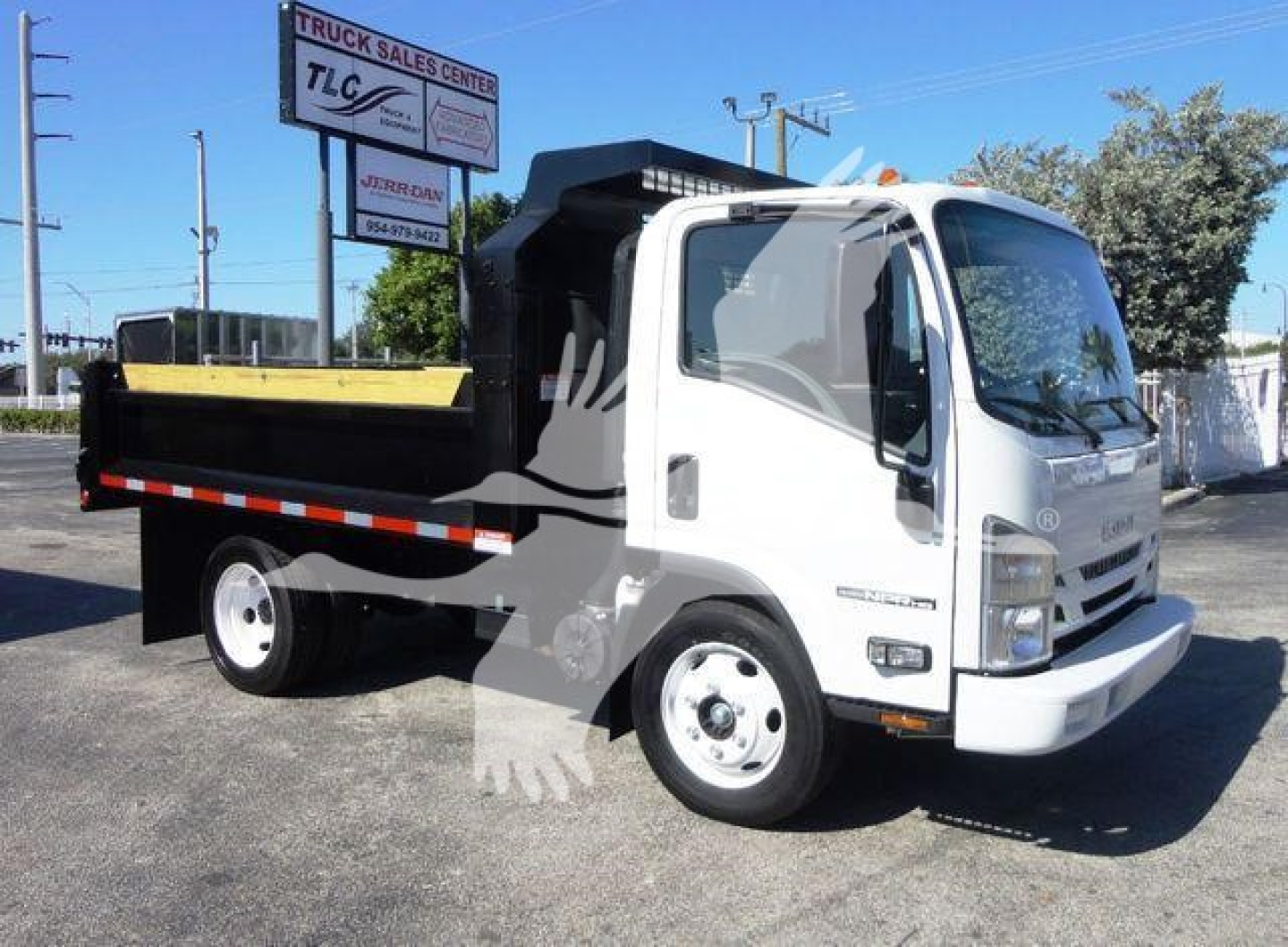 Isuzu NPR-HD dump truck showing white cab and black dump bed with reflective stripe.