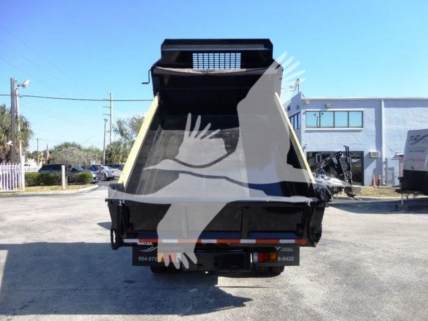Isuzu NPR HD dump truck bed with open cargo area viewed from rear, chassis and license area visible.