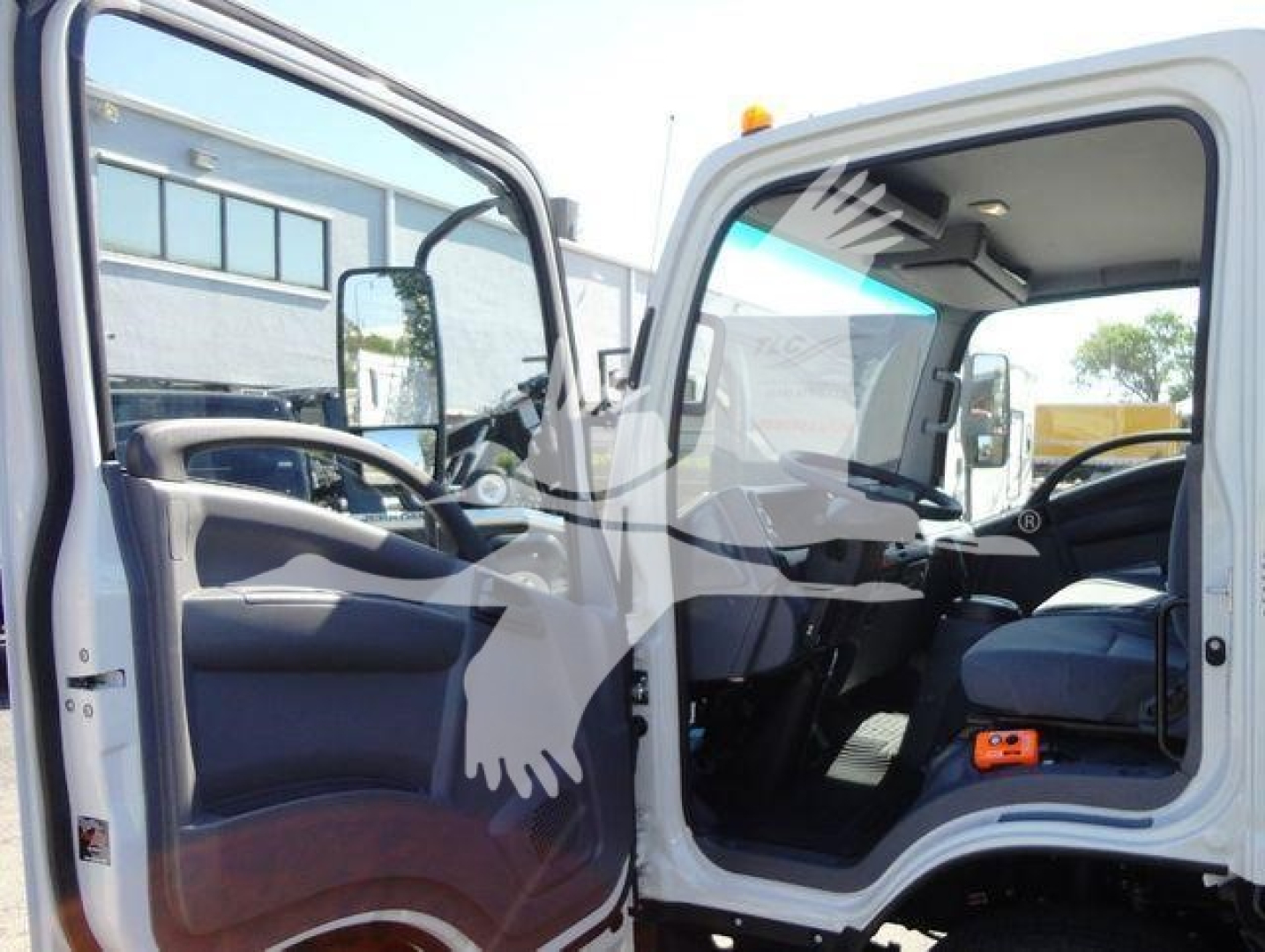 Isuzu NPR HD truck cab interior with driver door open; dashboard, steering wheel, and passenger seat visible.