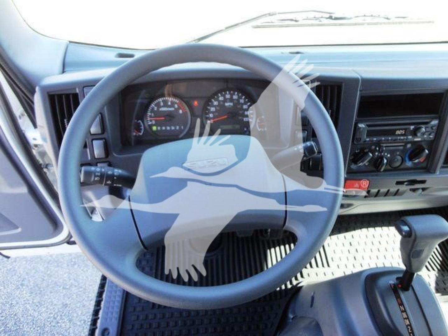 Isuzu NPR-HD truck interior steering wheel and dashboard visible from driver’s seat.