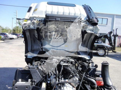 Isuzu NPR HD front-end cab and engine bay with visible engine components and wiring; front bumper area and hood.