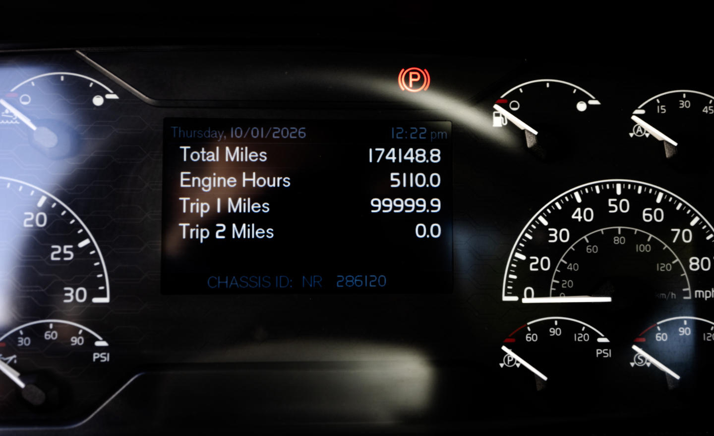 Truck dashboard showing digital display with Total Miles 17448.8, Engine Hours 510.0, Trip 1 Miles 99999.9, Trip 2 0.0, CHASSIS ID NR 286120; analog gauges around with speedo and tachometer. 