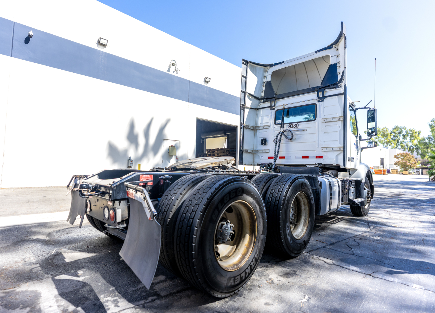 Volvo VNR truck rear view showing fifth wheel, dual rear axles, and cab with open sleeper area; visible tire treads and mud flaps.