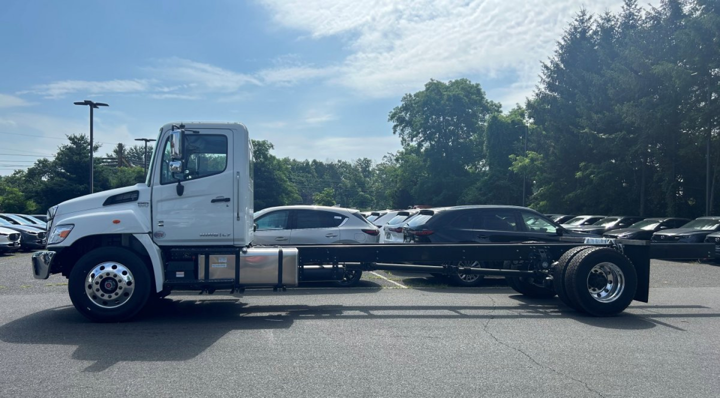 Tow truck chassis side view showing Hino L6 chassis and wheelset with white cab and long wheelbase.