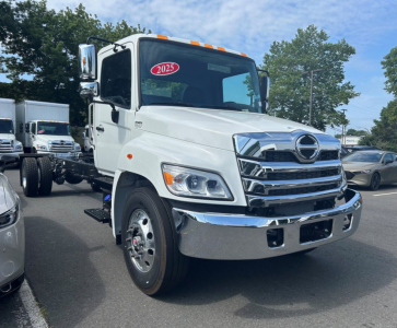 Hino L6 tow truck front view showing chrome grille, headlights, and bumper with 2025 sticker on windshield.