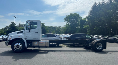 Tow truck chassis side view showing Hino L6 chassis and wheelset with white cab and long wheelbase.
