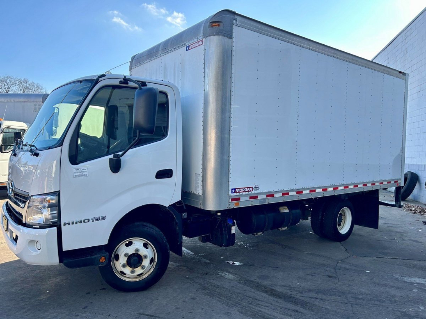 Box van truck: 2018 Hino 155 with cargo box, side view showing cab and box structure.