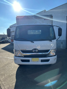 Front view of a white 2018 Hino 155 box truck showing Hino emblem, grille, headlights, and front bumper.