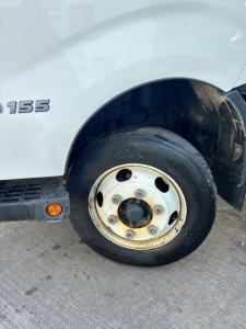 Hino 155 box van truck wheel and front fender showing 155 badge and wheel.