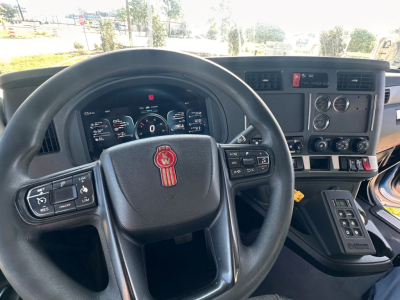 Kenworth T880S truck interior showing steering wheel, instrument cluster, and center console with controls and gauges.