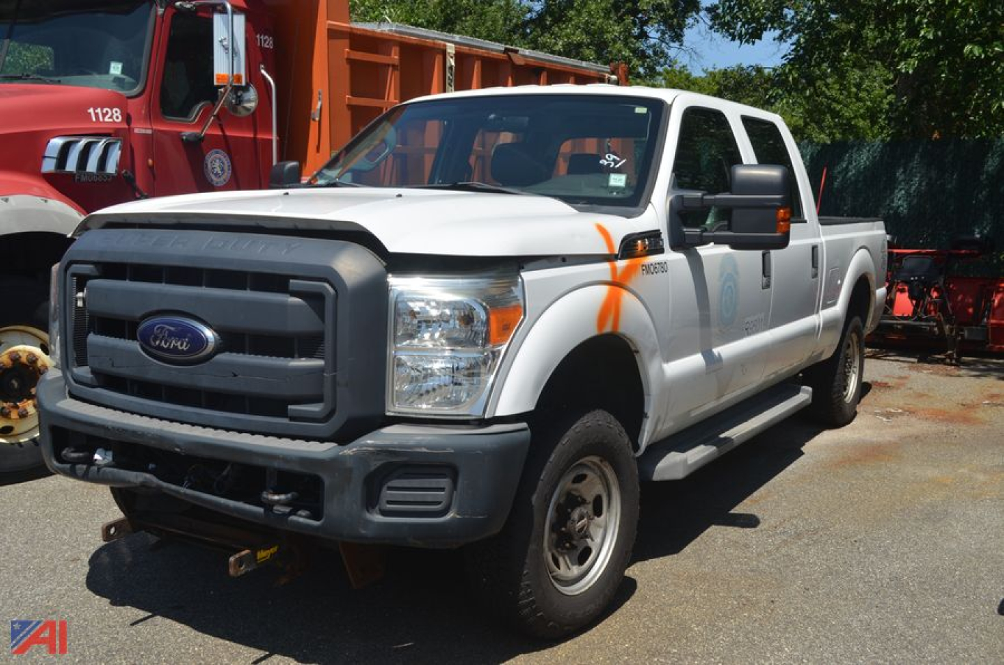 Ford F-250 Super Duty pickup truck in white with orange safety markings, front grille view, 4x4 badge, extended cab, gray front bumper, in a lot.