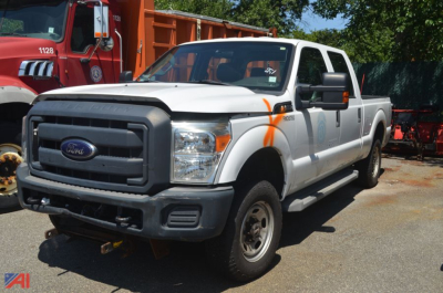 Ford F-250 Super Duty pickup truck in white with orange safety markings, front grille view, 4x4 badge, extended cab, gray front bumper, in a lot.