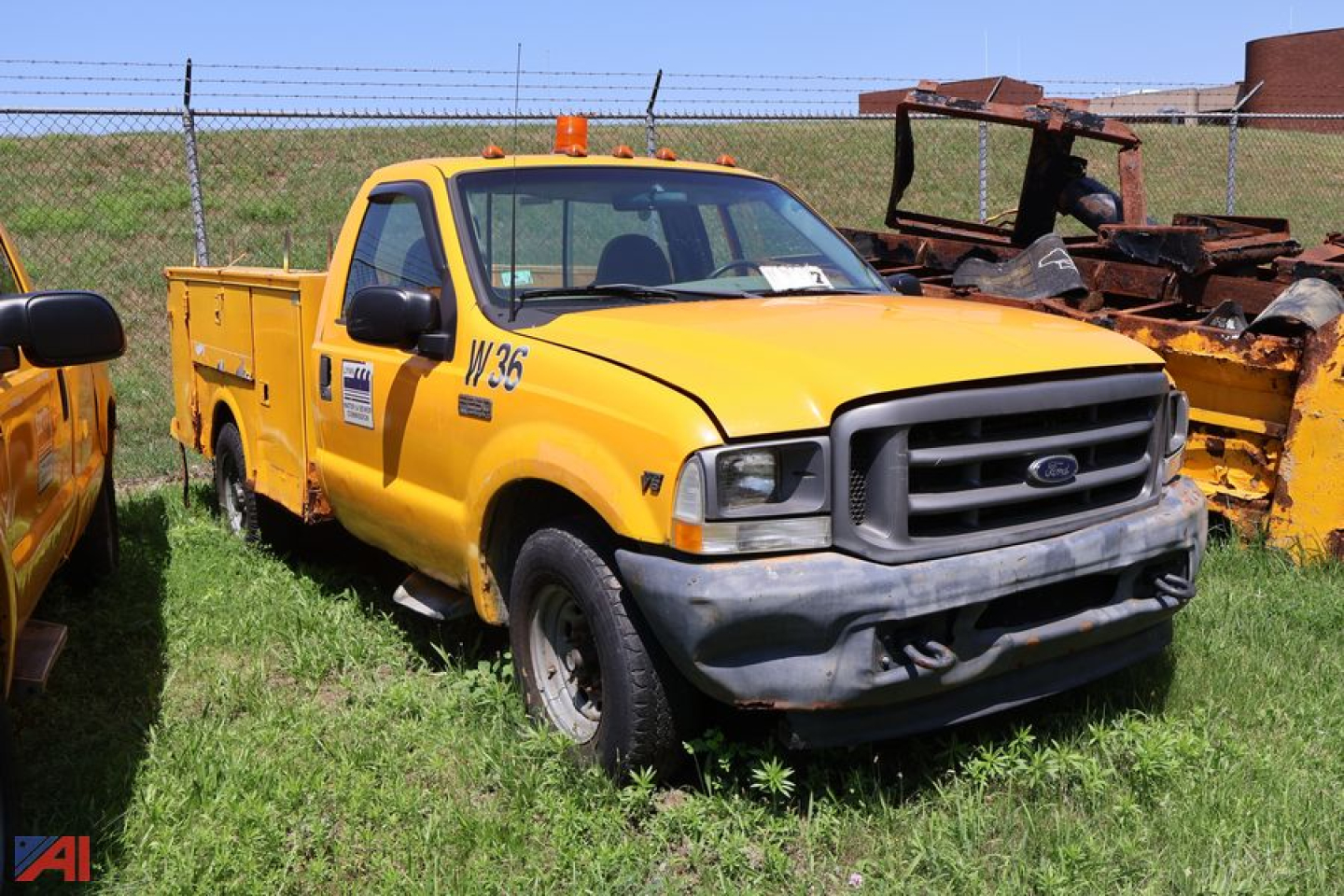 2002 Ford F-250 Super Duty utility truck yellow body front view with grille and winch area