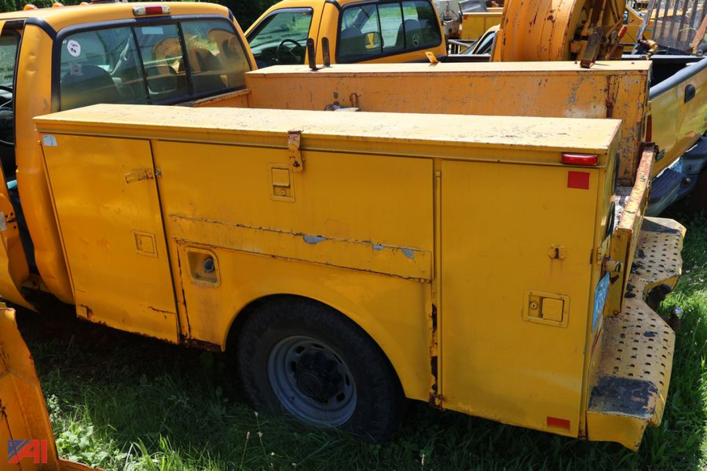 Service/Utility truck showing yellow utility body with storage compartments and rear access doors
