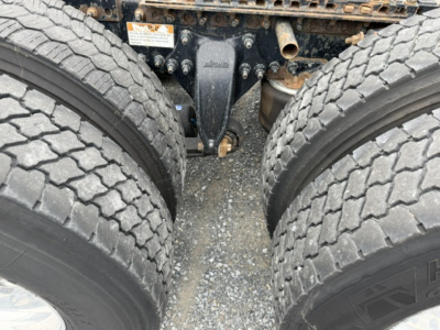 Freightliner Cascadia CA125DC undercarriage showing tandem drive axles and suspension components between dual rear wheels.