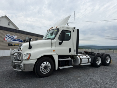 Truck side view of a white 2018 Freightliner Cascadia CA125DC conventional daycab with front bull bar, dual rear axles, fuel tanks, and a sleeper/cab design visible.