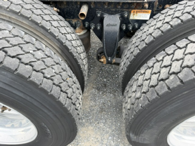 Freightliner Cascadia CA125DC chassis view showing dual rear axles and fifth wheel area with tires and suspension components.