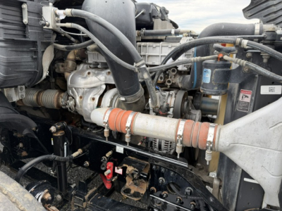 Freightliner Cascadia engine bay showing turbocharger piping and hoses with hoses and clamps visible.
