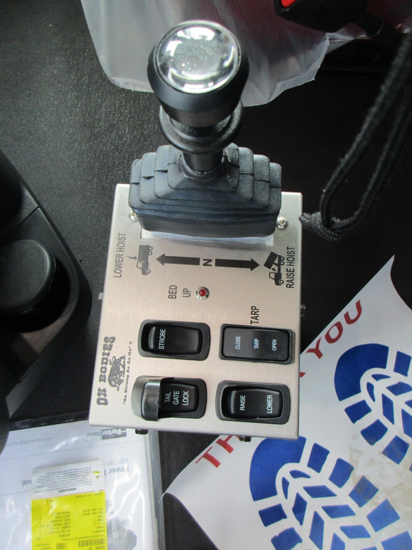 Dashboard control panel with levers and switches in a Western Star 49X cab; visible joystick-like lever and labeled buttons.