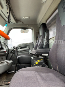 Cab interior of a 2016 Kenworth T880 truck with driver’s seat and center console visible.