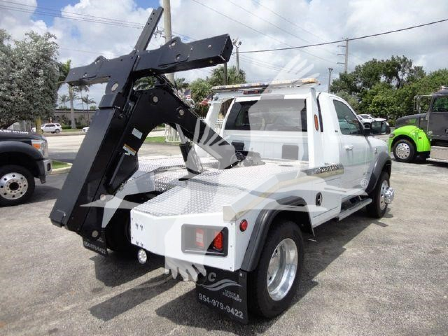 Tow truck bed with mounted hydraulic wrecker and winch on white 2024 Ram 4500 SLT in pickup configuration.