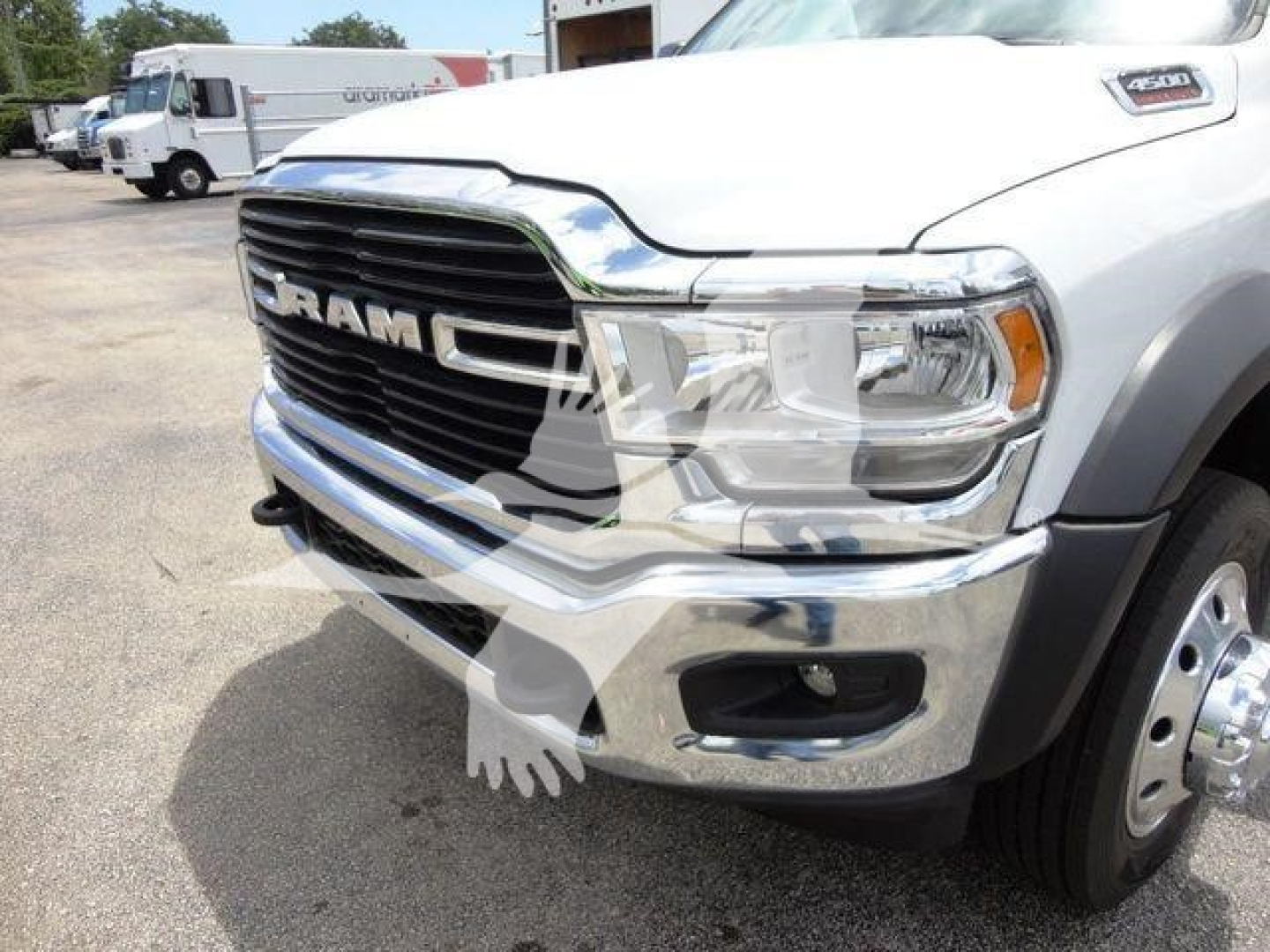 Ram 4500 front-left view showing chrome grille with RAM lettering, headlight, and bumper; white cab, SLT badge on fender.