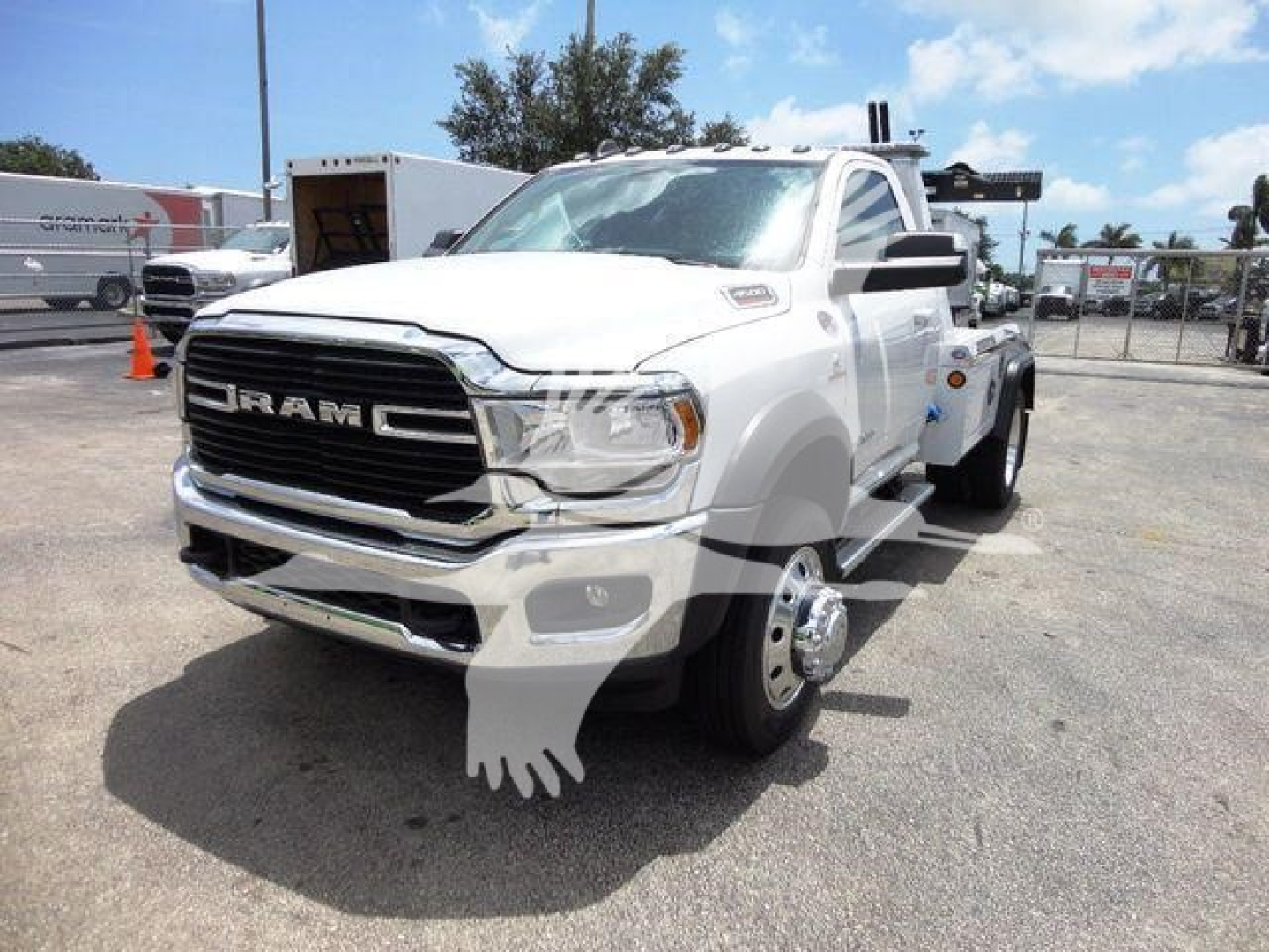 White Ram 4500 SLT heavy-duty truck in a lot, front grille with RAM lettering, tow winch equipment on the rear, side mirrors, large front bumper, chrome grille.