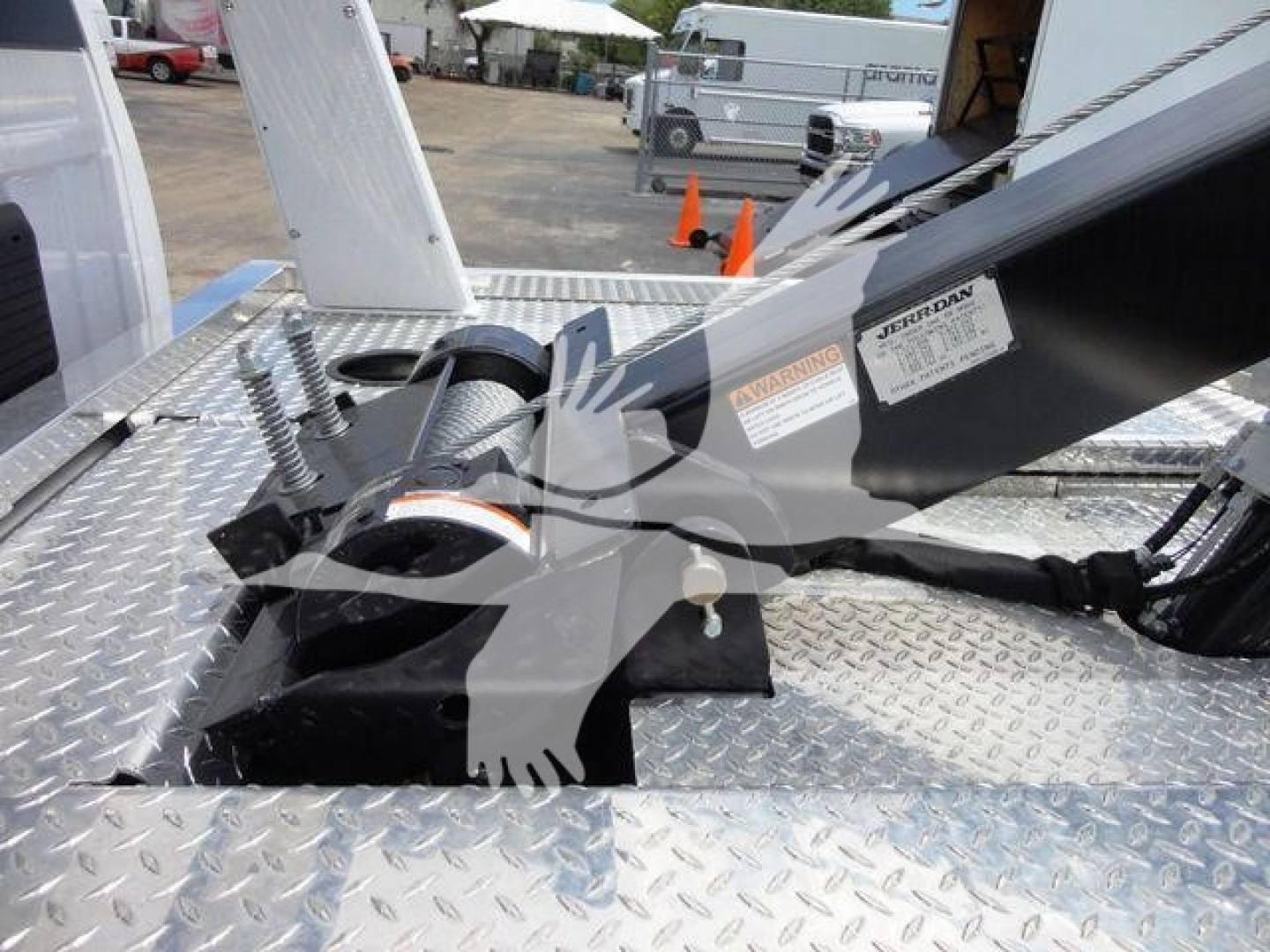Truck winch setup on aluminum diamond plate bed with hydraulic boom reads warning labels and Dan sticker visible.