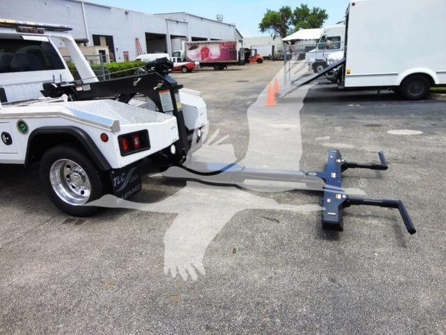 Ram 4500 SLT tow truck with winch hitch attachment and extended tow bar in a dealership lot.