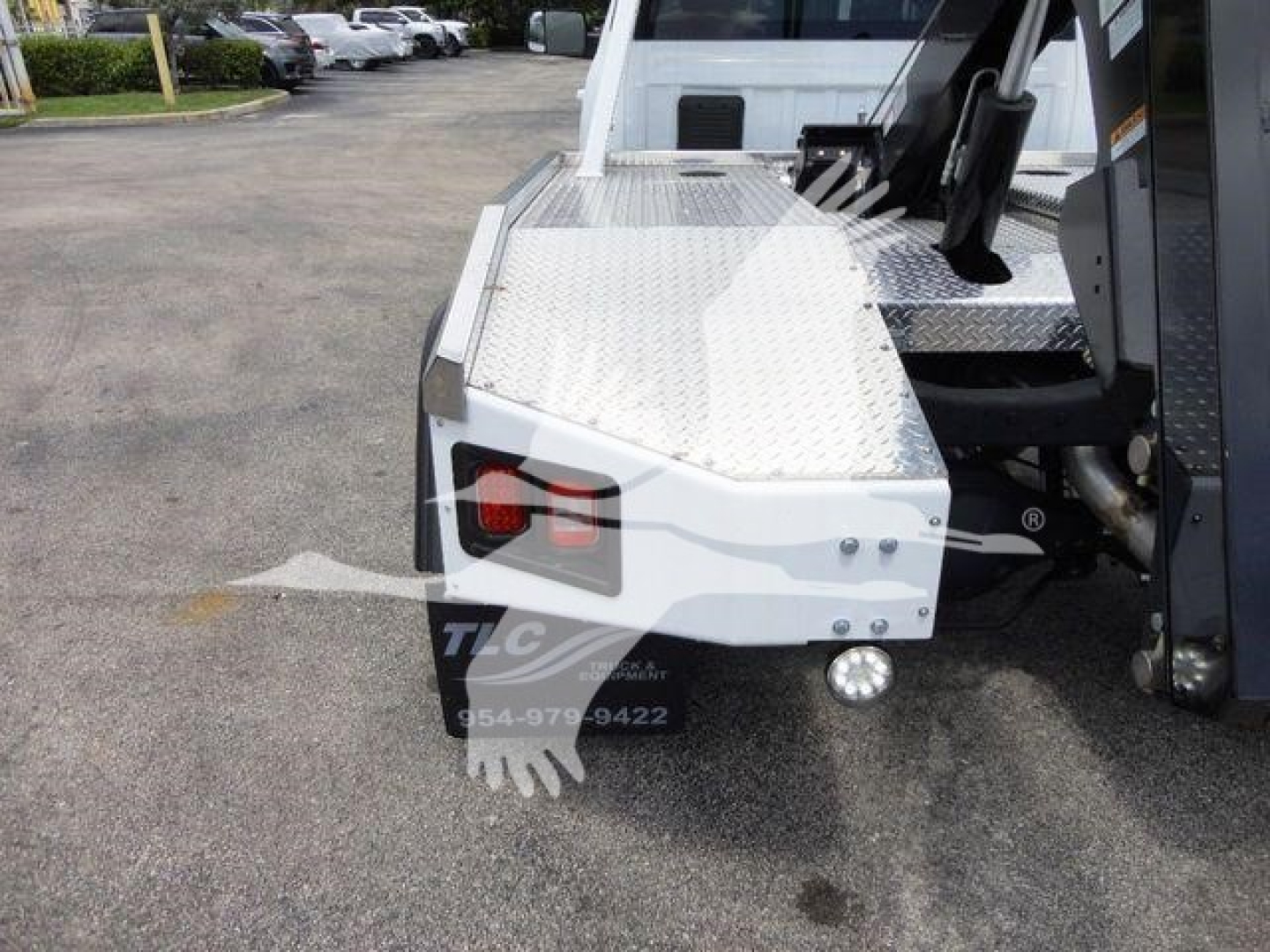 Ram 4500 SLT winch-equipped truck bed with aluminum diamond plate and mounted equipment; rear bumper area visible with tail light and fog light.