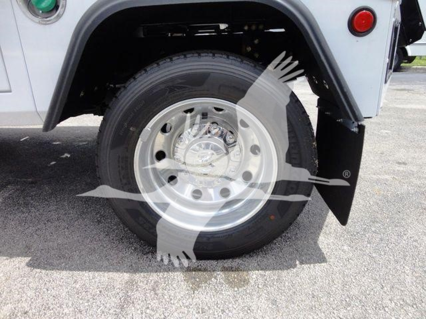 Truck wheel and fender showing steel wheel, tire, and mud flap on RAM 4500 SLT winch listing.