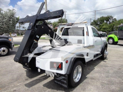 Tow truck bed with mounted hydraulic wrecker and winch on white 2024 Ram 4500 SLT in pickup configuration.