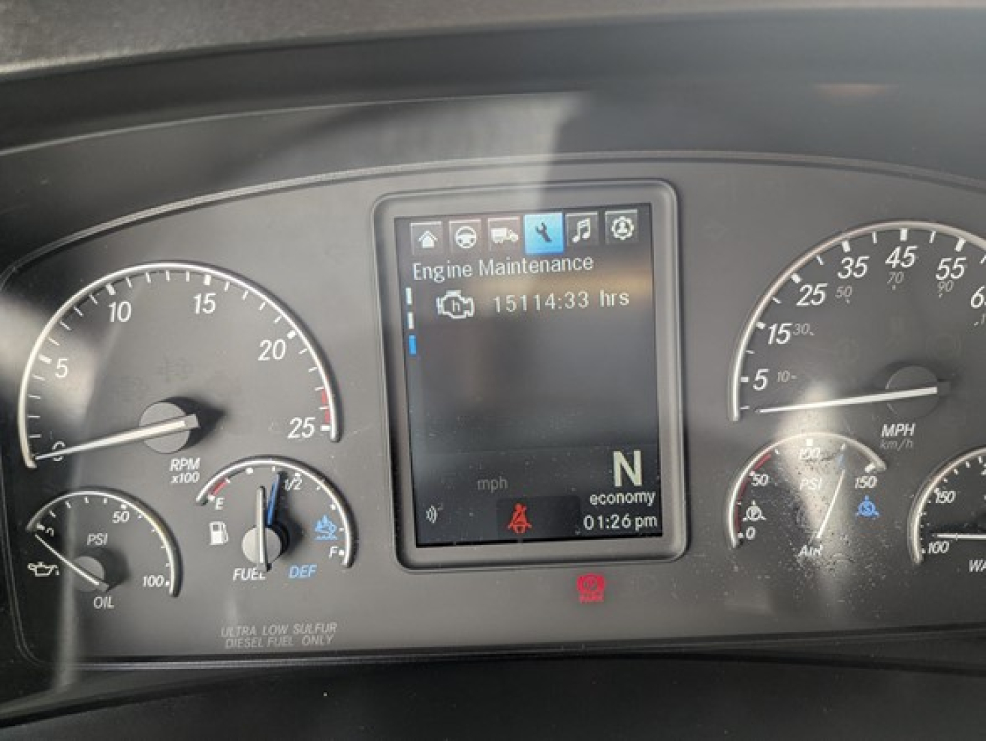Dashboard view of a 2022 Freightliner Cascadia 126 showing engine maintenance display and gauges.