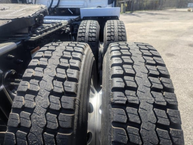 Truck axle view showing dual rear tires with aggressive tread pattern on Freightliner Cascadia 126 cab chassis.