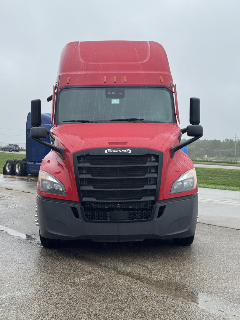 Truck front view of a red 2023 Freightliner Cascadia 126 sleeper cab showing grille, headlights, and bumper.