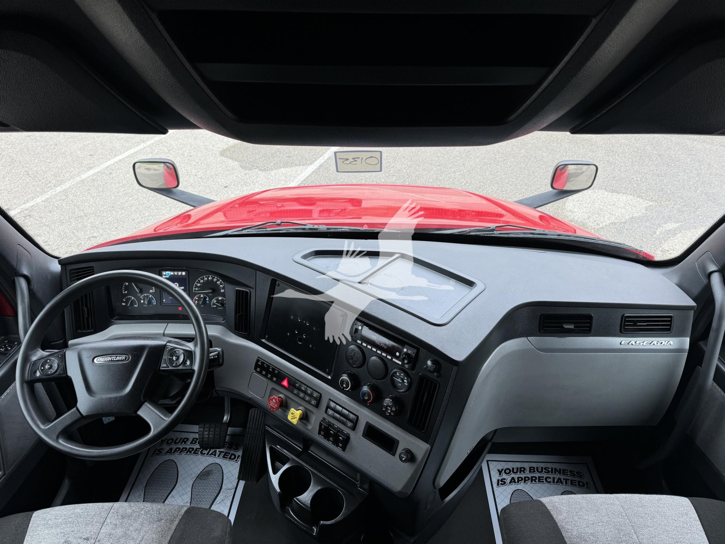 Freightliner Cascadia interior dashboard and steering wheel view from driver seat showing controls and gauges.