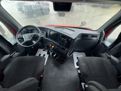 Cab interior of a 2023 Freightliner Cascadia 126 showing steering wheel dashboard and center console.