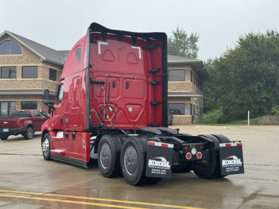 2023 Freightliner Cascadia 126 tractor truck rear view showing sleeper cab, triple rear axles, and Kordell truck decals on mudflaps.