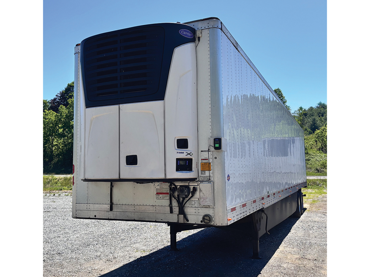 Utility trailer 2024 Utility 3000R reefer trailer with front refrigeration unit and white insulated sides, viewed from front-left corner in outdoor lot.