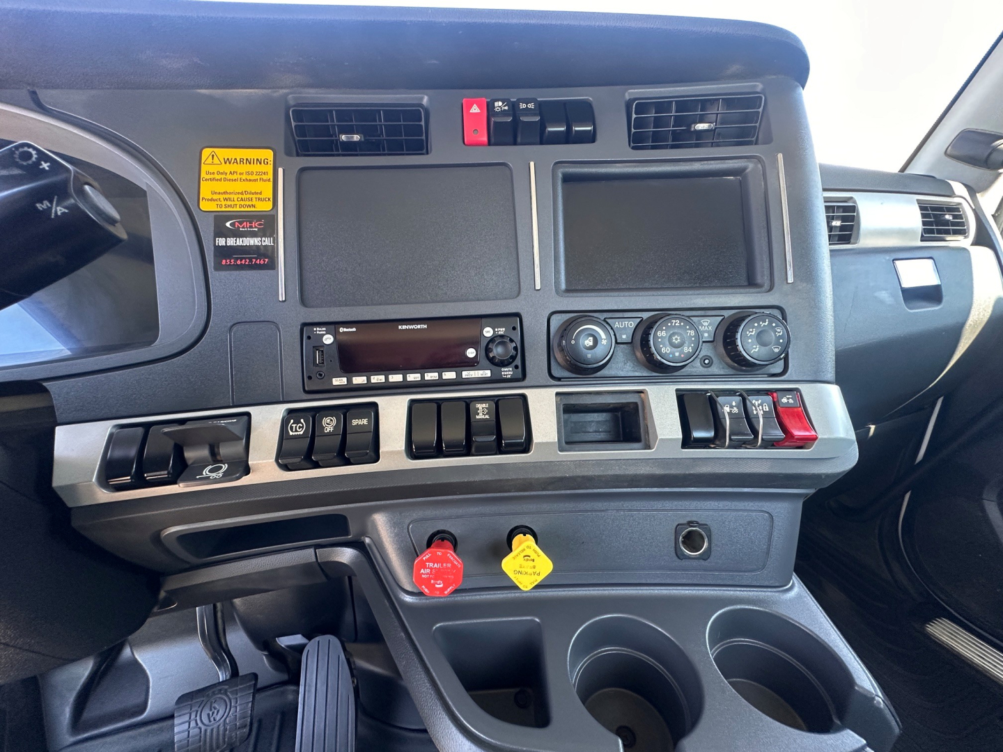 Kenworth T880 cab interior dashboard with gauges, vents, and control switches visible in a truck cab.