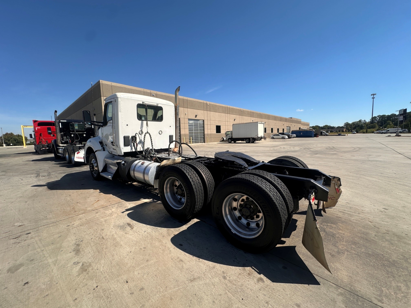 Kenworth T880 conventional daycab chassis showing dual rear axles and white cab.