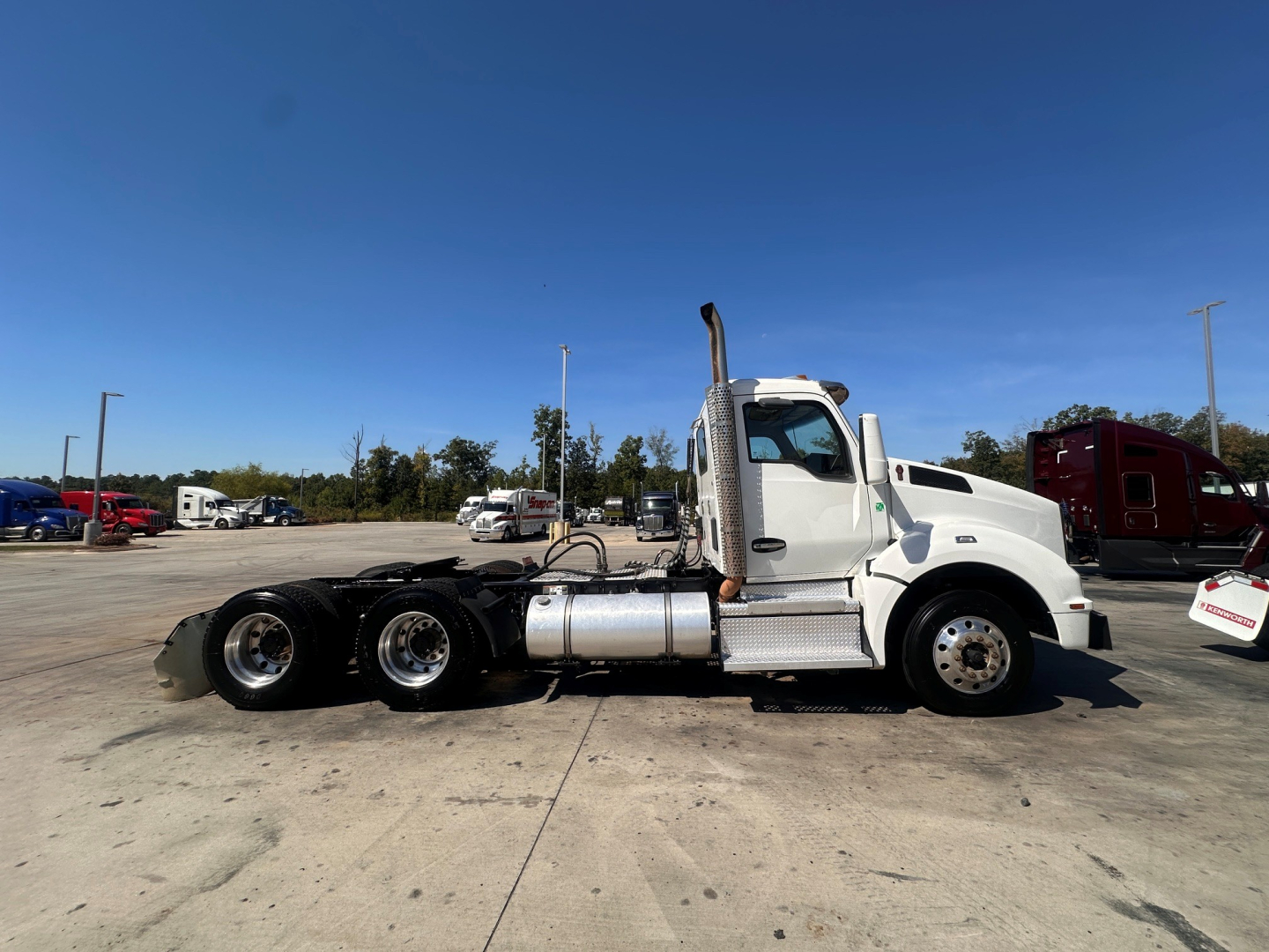 Kenworth T880 conventional daycab side view showing engine bay area and chassis with dual rear axles and fuel tanks