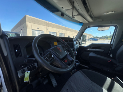 Kenworth T880 cab interior showing steering wheel with Kenworth emblem, dashboard controls, and driver area.