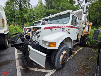 International 4800 dump truck in-service showing front plow and warning lights.