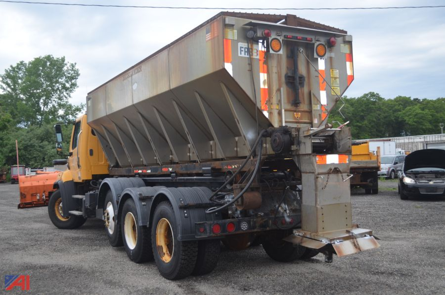 Freightliner 114 SD sander truck with plow attachment in a yard, side and rear views visible.