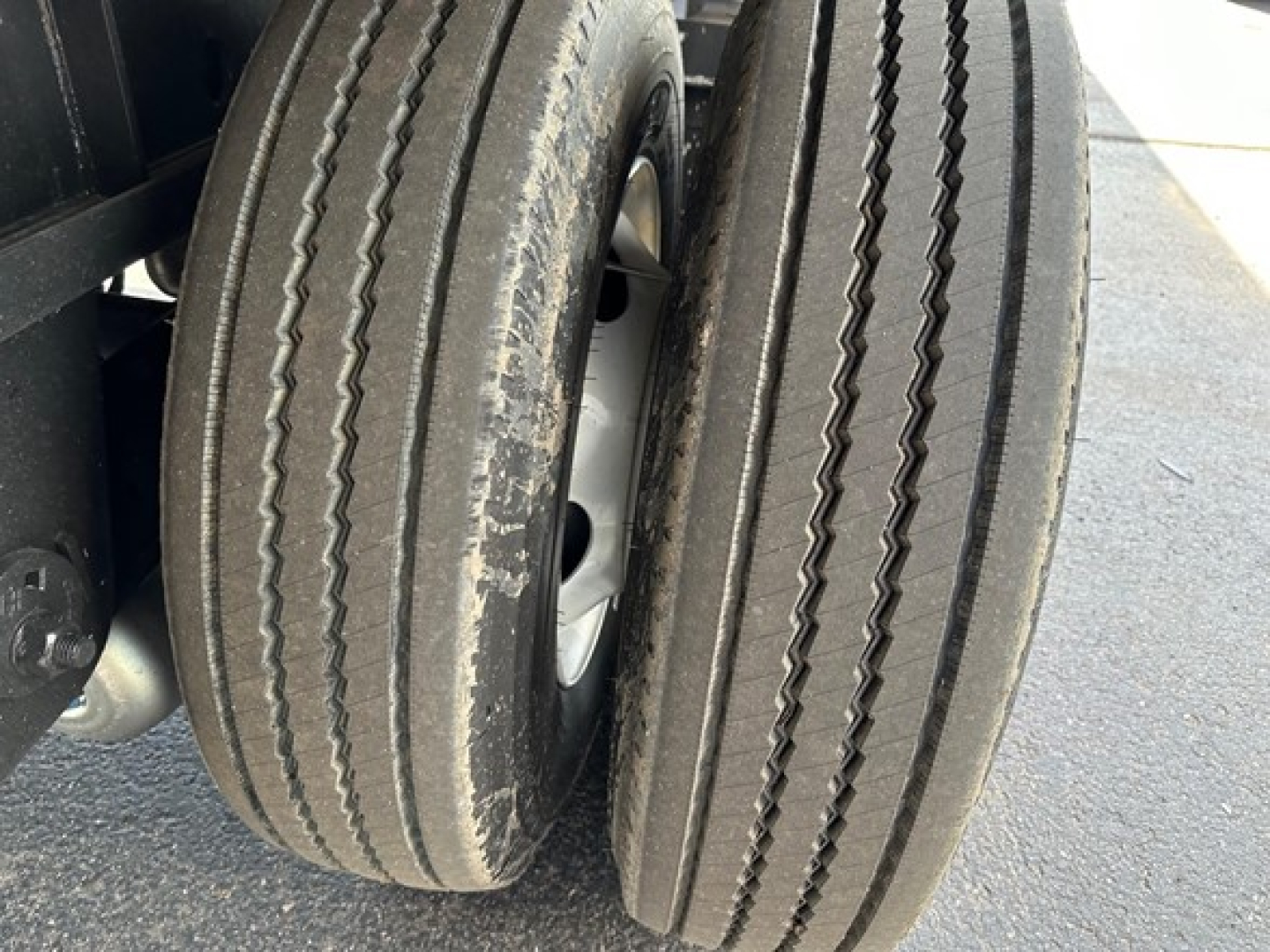 Tandem rear trailer wheels with dual tires on a Utility 4000Ae flatbed trailer.
