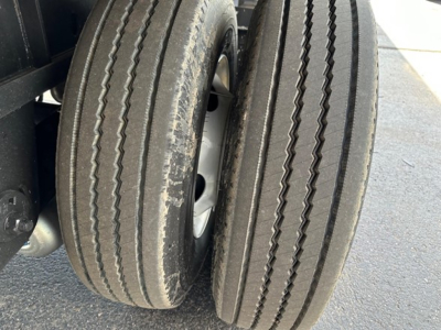 Tandem rear trailer wheels with dual tires on a Utility 4000Ae flatbed trailer.