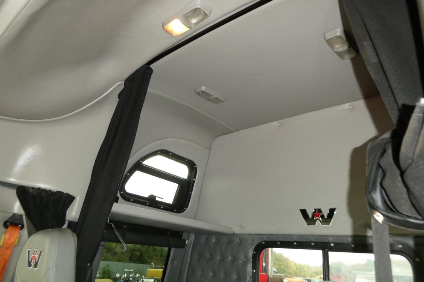 Western Star 5700XE truck interior showing upper bunk area and window with WW emblem.