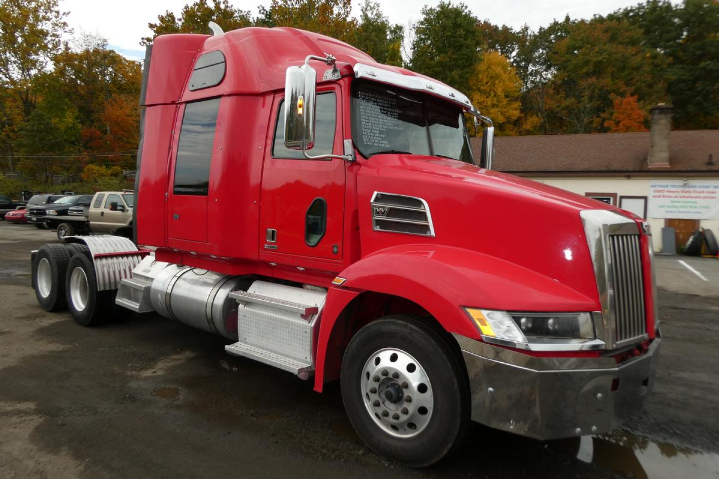 Red Western Star 5700XE truck in profile view showing cab and chrome fuel tanks